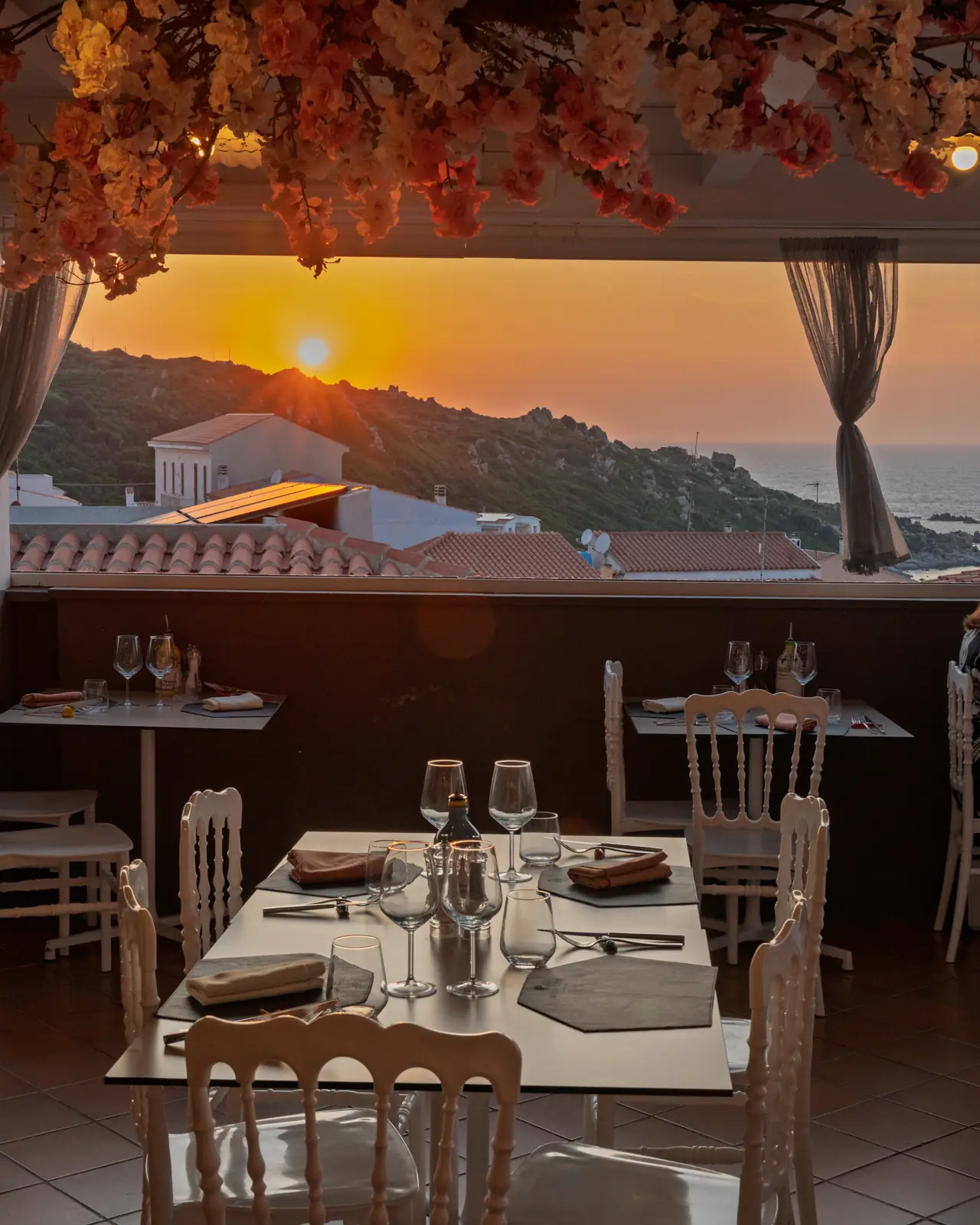 A table laid on the terrace with the sunset over the sea