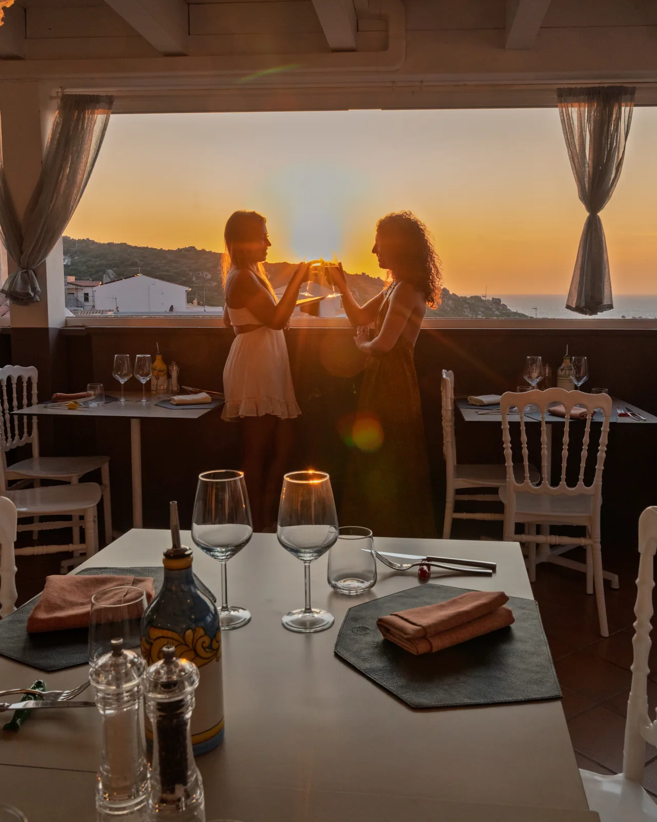 Tavolo apparecchiato in terrazza al tramonto